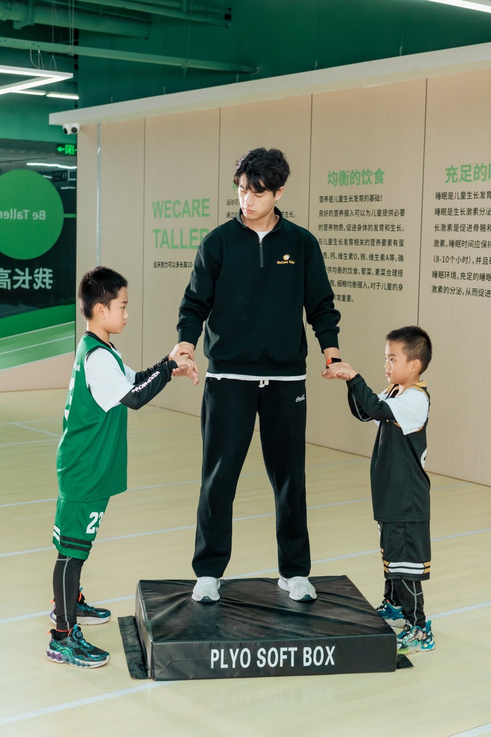 教练为孩子做站立姿态比对与生长发育评估